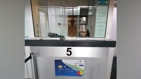 A cashier counter with the number 5 and a poster that looks like a GO GEORGE Smart Card.
