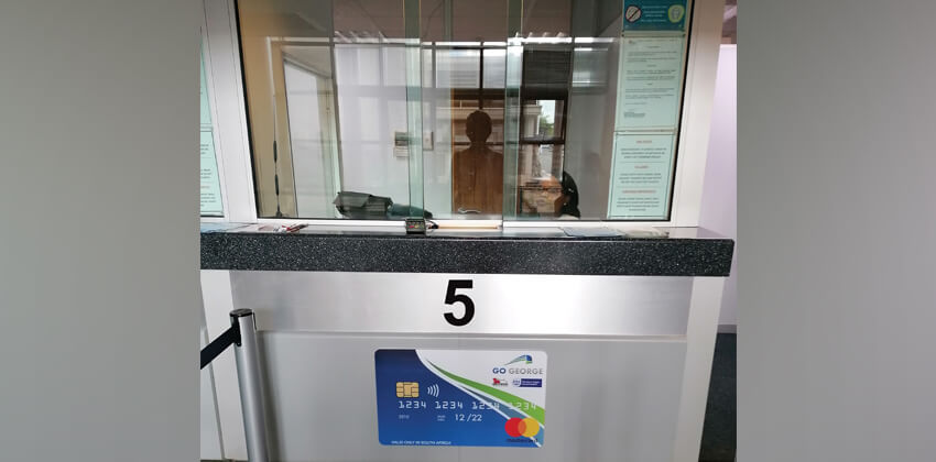 A cashier counter with the number 5 and a poster that looks like a GO GEORGE Smart Card.