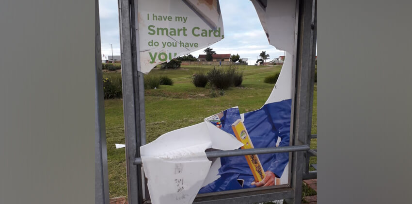 A GO GEORGE bus shelter with all the glass panels broken or cracked.