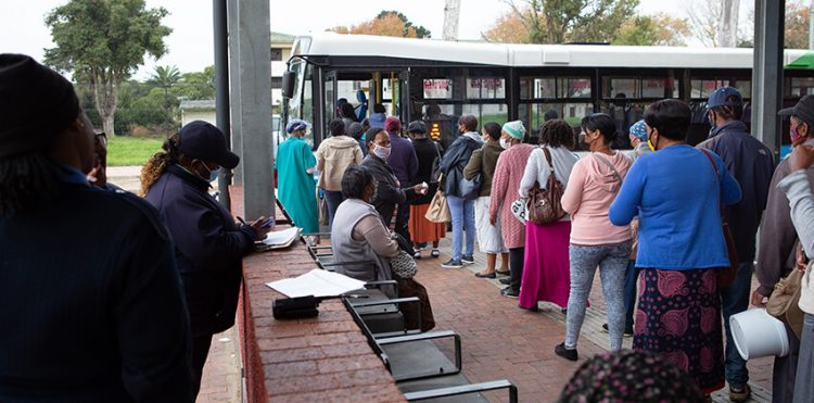 A long queue of passengers waiting to board a GO GEORGE bus