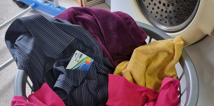 A basket of laundry with a GO GEORGE Smart Card sticking out from a shirt pocket.