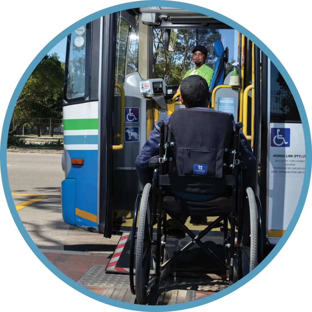 A person in a wheelchair boarding a bus via a ramp.