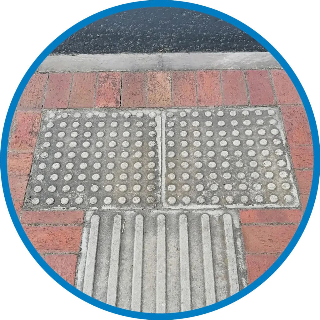 Tactile paving for blind passengers, built into the paving of a bus stop.