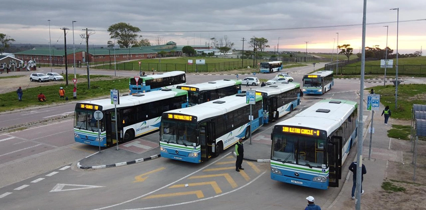 Multiple GO GEORGE blue and white buses lined up at the Thembalethu terminal at dusk.